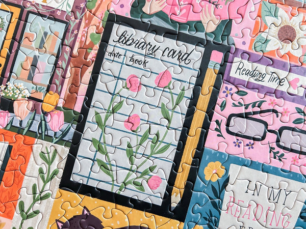 Jigsaw puzzle pieces with book-themed designs including a library card and reading glasses.