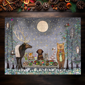 Completed jigsaw puzzle with art of a festive dinner scene featuring whimsical animals. Puzzle on top of dark table with pinecones and holiday items.
