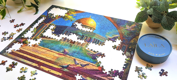 Jigsaw puzzle with a completed section showing a decorative illustration of a domed building with a pool and pigeons, framed by an archway.