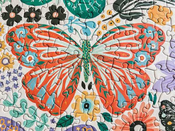 Colorful butterfly puzzle with flowers on a white background
