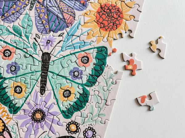 Close up of Butterfly and floral puzzle with incomplete pieces on a white background