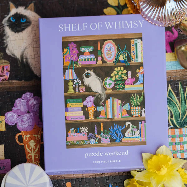 Shelf of Whimsy puzzle packaging with a cat on shelves illustration, surrounded by decorative items.