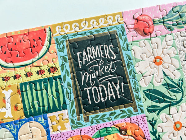 Colorful puzzle with 'Farmers Market Today!' sign and garden-themed pieces.