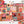 A colorful autumn-themed jigsaw puzzle with pieces scattered around it on a white surface, alongside the puzzle box and partial matching puzzle pieces. The puzzle features a patchwork design of pumpkins, leaves, plaid patterns, and fall motifs in orange, pink, teal, brown, and cream tones.