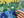 Hand holding a green puzzle piece over a partially completed puzzle with floral patterns.