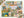 A completed 1000-piece jigsaw puzzle featuring a colorful collage of outdoor and camping-themed illustrations, including a campfire, tent, camper, pinecone, bicycle, and nature scenes. The puzzle is displayed on a white background with the product box visible in the corners.