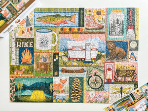 A completed 1000-piece jigsaw puzzle featuring a colorful collage of outdoor and camping-themed illustrations, including a campfire, tent, camper, pinecone, bicycle, and nature scenes. The puzzle is displayed on a white background with the product box visible in the corners.