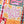 A close-up of a completed jigsaw puzzle featuring a colorful autumn design with the words 'Hello fall' in pink script, orange pumpkins, teal leaves, and plaid patterned sections.