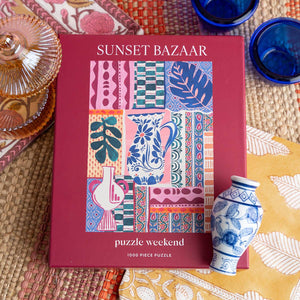 Puzzle box titled 'Sunset Bazaar' shown with decorative elements on a patterned surface.