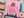 Jigsaw puzzle with a pink section featuring a person holding a book with a floral cover, surrounded by colorful puzzle pieces.