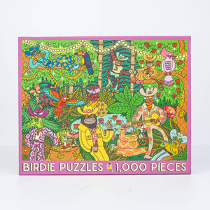 Photo of a jigsaw puzzle box against a white surface/wall. Box shows an illustration of a busy jungle scene with animals dressed up in funky human outfits playing guitars and holding a party. 