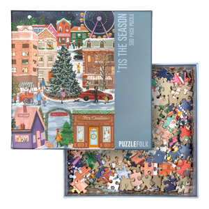 Puzzle box with a Christmas-themed illustration overtop the box holding many puzzle pieces.