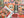 The back of a puzzle box atop a completed version of the puzzle showing halloween-themed artwork arranged in a grid collage.