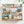 A 1000-piece jigsaw puzzle box by Spaghetti Tree, featuring a colorful collage of rustic outdoor illustrations including a camper, campfire, fish, bear, tent, and nature motifs, displayed on a light surface with soft plant shadows.