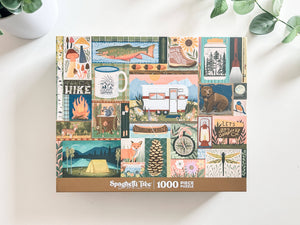 A 1000-piece jigsaw puzzle box by Spaghetti Tree, featuring a colorful collage of rustic outdoor illustrations including a camper, campfire, fish, bear, tent, and nature motifs, displayed on a light surface with soft plant shadows.