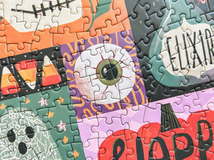 A close up of a halloween themed puzzle showing artwork of an eyeball atop a purple background with orange squiggles. Portions of additional halloween art are also shown.