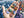 Colorful puzzle pieces held in a hand with a partially completed puzzle in the background.