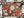 A completed and partially assembled 1000-piece jigsaw puzzle featuring a festive Christmas floral and holiday garland design, styled on a white surface with pine branches, pinecones, and a few loose puzzle pieces.