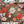 A completed and partially assembled 1000-piece jigsaw puzzle featuring a festive Christmas floral and holiday garland design, styled on a white surface with pine branches, pinecones, and a few loose puzzle pieces.