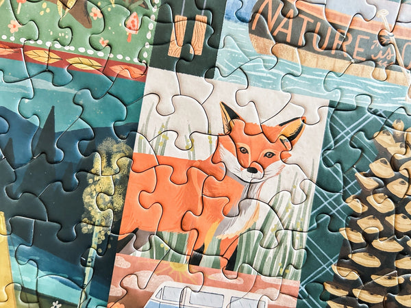 Close up of completed jigsaw puzzle section with a fox illustration in focus, surrounded by other nature themed artwork