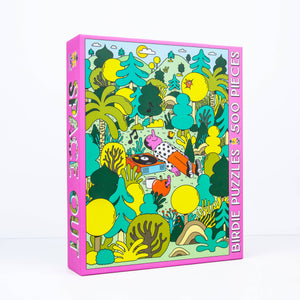 Photo of an angled jigsaw puzzle box showing illustration of a man lying in the middle of a bunch of trees listening to music on a record player.