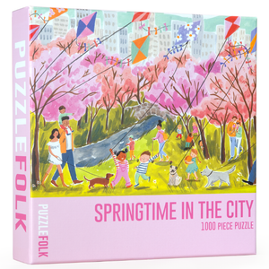 Puzzlefolk puzzle box for Springtime in the City 1000 piece puzzle showing illustration of a beautiful park scene showing people walking, flying kites and enjoying the day. 