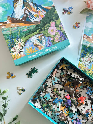 Jigsaw puzzle with pieces and packaging on a white surface