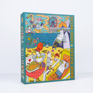 Colorful puzzle box with cartoon birds wearing bathing suits eating french fries and a beach scene on a white background
