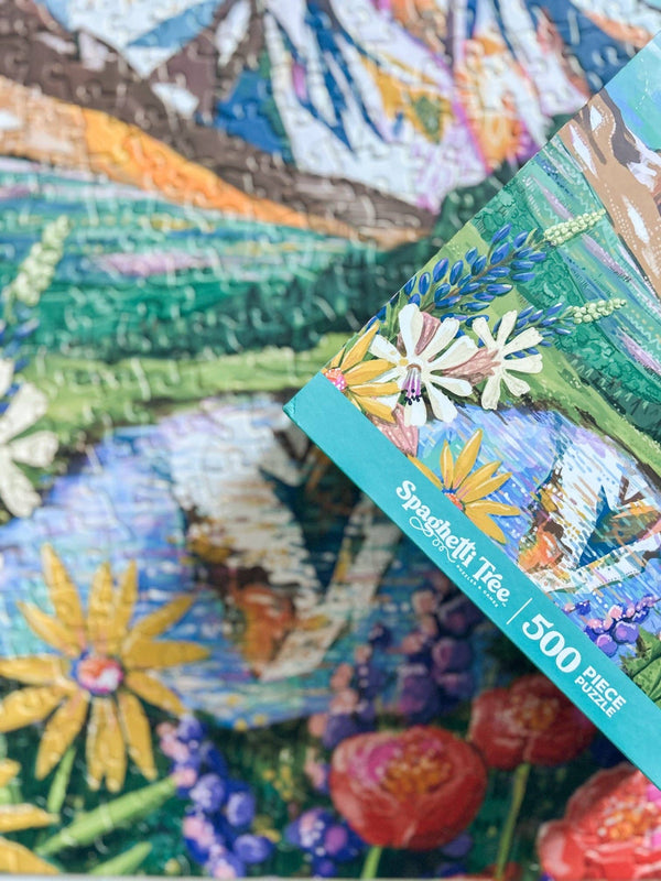 Colorful puzzle with floral design and the corner of a puzzle box with Spaghetti Tree branding visible