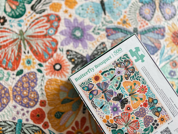 Jigsaw puzzle box with butterfly design on a colorful butterfly-themed background