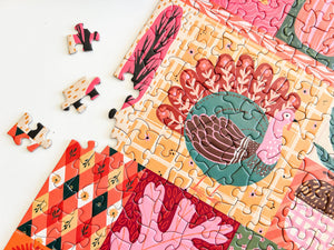 A colorful jigsaw puzzle featuring a stylized turkey and autumn-themed patterns, with several loose puzzle pieces scattered on a white surface.