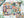 Colorful puzzle with farmers market-themed design on a white surface surrounded by plants and a poster of the puzzle and box lid.