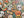 A 500-piece jigsaw puzzle box placed diagonally over a completed Halloween-themed puzzle featuring sugar skulls, pumpkins, leaves, spiders, and candles on a dark background.