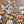 A 500-piece jigsaw puzzle box placed diagonally over a completed Halloween-themed puzzle featuring sugar skulls, pumpkins, leaves, spiders, and candles on a dark background.