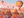 Colorful hot air balloons over a scenic landscape with rock formations and a balcony.
