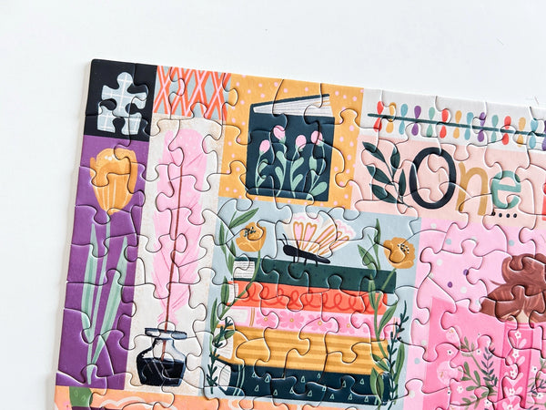 Close up of a puzzle with colorful book-themed illustrations on a white background