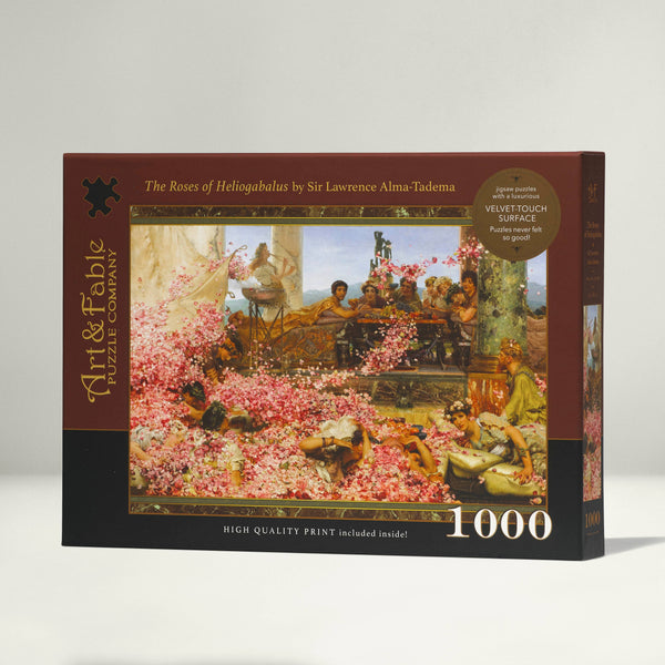 Jigsaw puzzle box with artwork showing a classical painting of people lounging around with flower petals. Box has 'Art & Fable' branding with the title of The Roses of Heliogabalus by Sir Lawrence Alma-Tadema on a white background