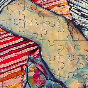 Colorful close up of the Serious Snack puzzle showing a cropped image of an illustration of a mans hand atop a colorful striped background.