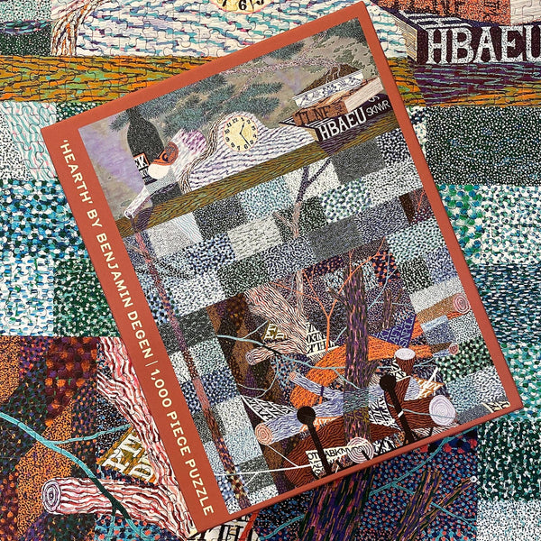 Colorful puzzle box with patterned fireplace design over a close-up of the completed puzzle