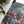 Colorful leaf-patterned fabric on a white surface with a plant in the background