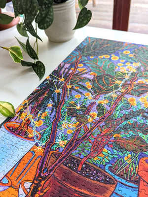 Colorful puzzle with a nature-themed design on a white surface, next to a potted plant.