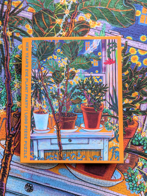 Puzzle box with plant-themed artwork on a completed version of the puzzle.