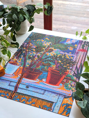 Colorful puzzle with a floral design on a table surrounded by plants