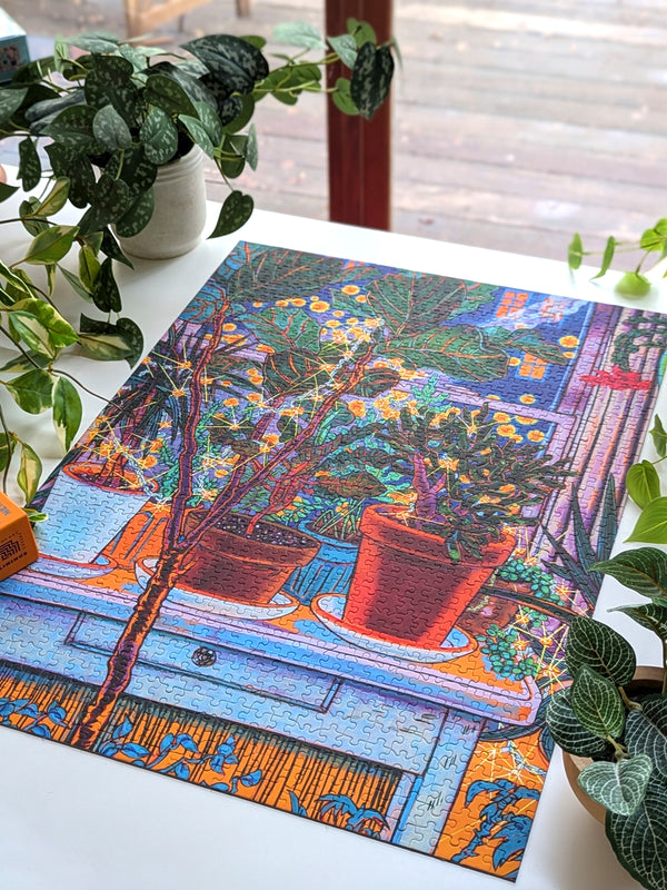 Colorful puzzle with a floral design on a table surrounded by plants