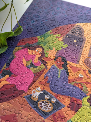 Close up of completed puzzle showing two women chatting with each other with drinks and snacks on a tray nearby. 