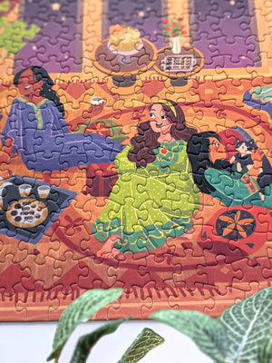 Close up detail of completed Girls Night puzzle showing three women, two chatting and one playing with a cat. 