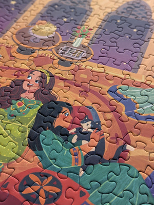 Close up detail of completed Girls Night puzzle showing two womens faces, one is playing with a cat and the other is smiling. 