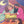 Close up detail of a woman applying henna design to another woman's arm while a woman nearby admires the design on her own arm. 