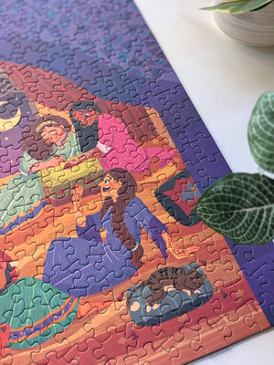 Close up of Girls Night puzzle showing women enjoying each others company and a small cat sleeping on a pillow. 