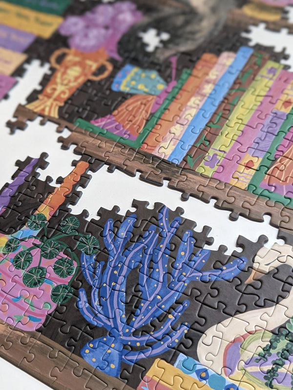 Partial puzzle with colorful design featuring an illustration of a vase of flowers, books, and plants.